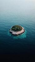 Lush green island surrounded by clear blue ocean waters in daylight photo