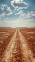 Expansive desert landscape featuring winding road surrounded by sand dunes and distant mountain range photo