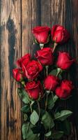 Bouquet of fresh red roses arranged on a rustic wooden background photo