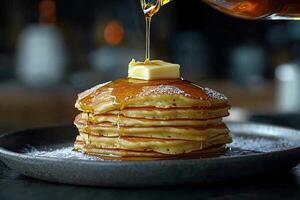 Stack of fluffy pancakes topped with butter and syrup ready to be enjoyed at breakfast photo