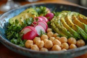 Colorful vegetable platter with chickpeas, radishes, and avocado on a decorative plate photo