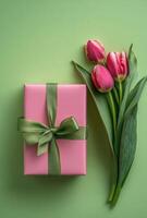 Colorful gift box and fresh tulips on vibrant green background in spring setting photo