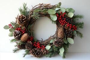 Holiday wreath decorated with pinecones and berries on white background photo