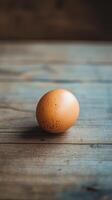 Unique speckled egg resting on a rustic wooden surface in soft natural light photo