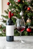 Festive wine bottle and glass near a decorated Christmas tree with warm lights photo
