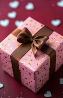 Colorful gift box with a bow on a red surface scattered with heart decorations photo