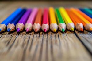 Colorful pencils arranged in a straight line on a wooden surface for creative activities photo