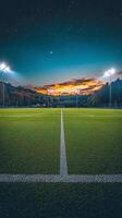 Nighttime view of a well-lit soccer field with bright stadium lights and clear sky photo