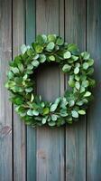 Decorative green wreath made of fresh leaves and berries on wooden background photo