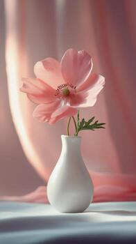 Elegant pink flower in a simple white vase against a soft gray background photo