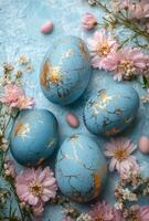 Decorative blue Easter eggs with gold accents surrounded by flowers and bunnies photo