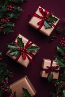 Gifts wrapped in brown paper with red ribbons and holiday decorations on dark background photo
