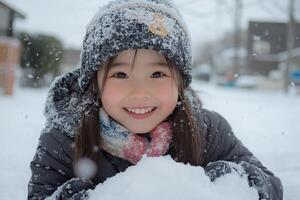Young girl playing in fresh snow on a winter day wearing a red hat and coat photo