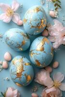 Decorative blue Easter eggs with gold accents surrounded by flowers and bunnies photo