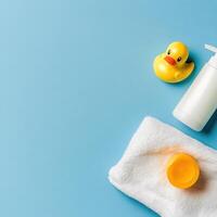 Yellow rubber duck and bath products on blue background for a playful baby bathing experience photo
