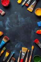 Colorful arrangement of paintbrushes and paint containers on a black surface for creative projects photo