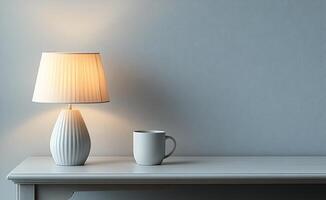 Elegant lamp and white mug on a wooden table against a soft gray wall photo