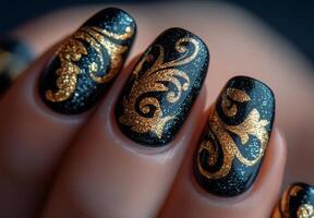 Elegant black and gold glitter nail art design with swirling patterns photo