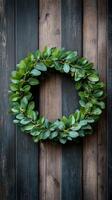 Decorative green wreath made of fresh leaves and berries on wooden background photo