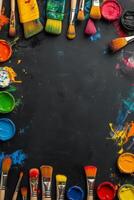 Colorful arrangement of paintbrushes and paint containers on a black surface for creative projects photo
