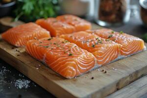 Fresh salmon fillets prepared on a wooden cutting board with herbs and spices photo