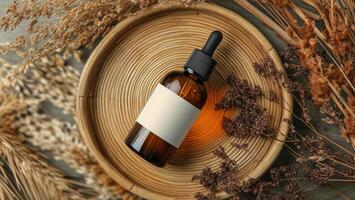 Rustic display of essential oil bottle on natural wooden plate with dried herbs and flowers photo