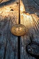 Bitcoin coin resting on a wooden surface illuminated by natural light at sunset photo