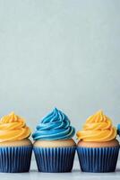 Colorful cupcakes with blue and yellow frosting on a light background photo