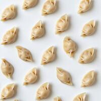 Dumplings arranged neatly on a white surface for culinary display and preparation in a kitchen setting photo