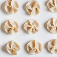 Dumplings arranged neatly on a white surface for culinary display and preparation in a kitchen setting photo