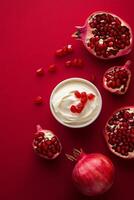 Creamy dessert topped with pomegranate seeds on a vibrant red backdrop photo