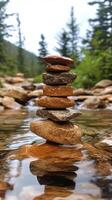 Stones stacked carefully in a tranquil stream surrounded by lush greenery and tall trees photo