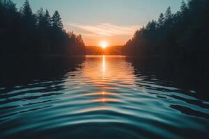 Sunset over tranquil lake surrounded by autumn trees reflecting on calm water photo