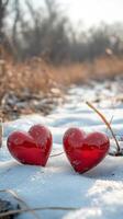 Red hearts resting on snow create a cozy winter atmosphere in a chilly landscape photo