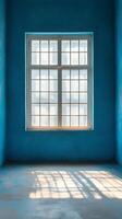 Bright blue room with large window casting shadows in afternoon light photo