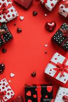 Gift boxes and chocolates arranged on a vibrant red background for a festive celebration photo