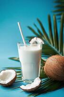 Refreshing coconut drink served with straws and garnished with green leaf photo