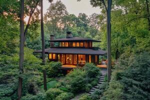 Charming wooden cabin surrounded by lush forest under soft lighting at dusk photo