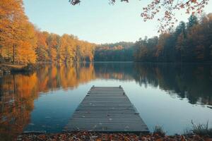 Tranquil wooden dock extending into calm lake surrounded by misty trees at dawn photo