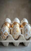 Decorative eggs arranged in an egg carton with intricate patterns and gold accents photo