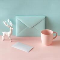 Colorful envelope, ceramic mug, and deer decoration on a pastel pink background photo
