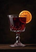 Elegant red cocktail with a slice of orange garnish in a glass photo
