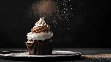 Decadent chocolate cupcake with frosting and cocoa powder dusting in dimly lit kitchen photo