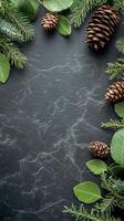 Natural pinecones arranged among green leaves on dark slate background for decorative display photo