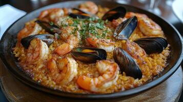 Delicious seafood paella served in a traditional skillet with shrimp and mussels photo