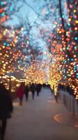 Giant illuminated Christmas tree adorned with bright lights in a bustling urban square during winter photo