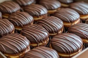 Assorted chocolate glazed donuts arranged in a neat box on a marble countertop photo