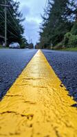 Yellow line on a quiet street captured under clear blue sky during daytime hours photo