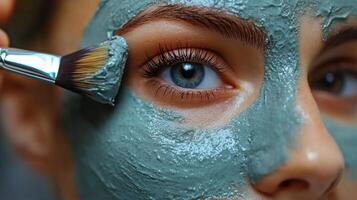 Relaxing facial treatment featuring a woman applying a green clay mask at a spa photo