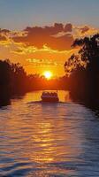 Sunset cruise on a serene river with golden reflections and colorful sky photo
